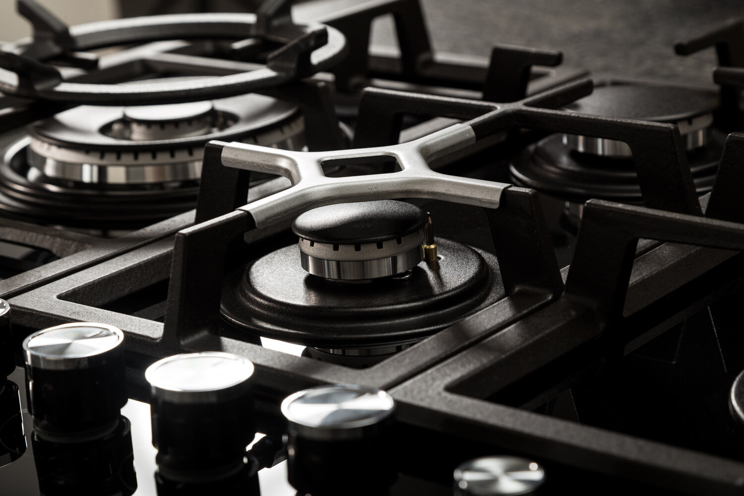 Trzy patelnie z przygotowanym jedzeniem: ravioli, marchewki i medaliony mięsne.