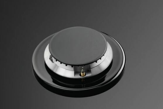 Zbliżenie czarnego palnika gazowego z błyszczącą, czarną powierzchnią.