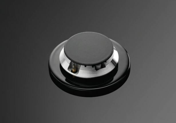 Zbliżenie czarnego pokrętła sterowania płyty gazowej.