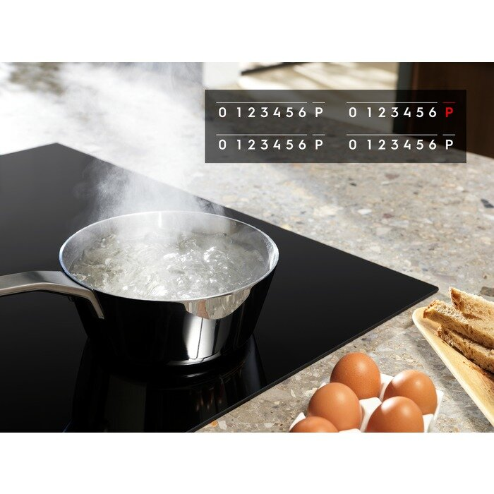 Czarna płyta grzewcza z wrzącą wodą w garnku, jajkami i cyfrowymi kontrolkami.