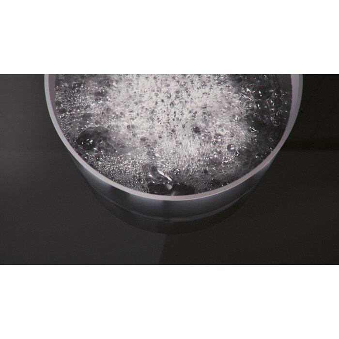 Garnek wrzącej wody, widziany z góry, na czarnej powierzchni.