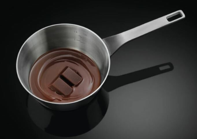 Garnek ze stali nierdzewnej z roztopioną czekoladą w środku.