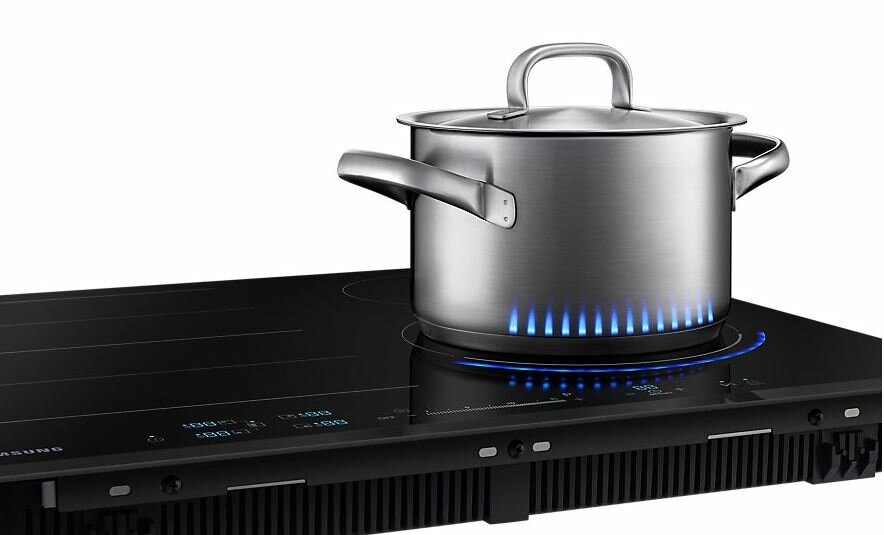 Garnek ze stali nierdzewnej na czarnej płycie grzewczej z niebieskimi światłami przypominającymi płomienie.