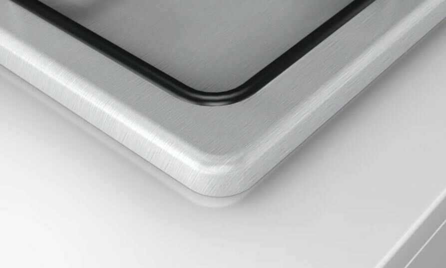 Zbliżenie na szczotkowaną metalową powierzchnię z czarnym obramowaniem.