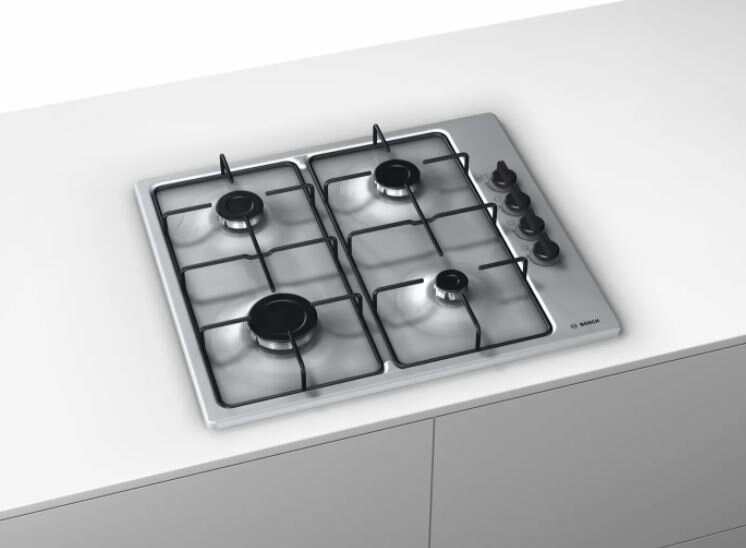 Wbudowana płyta gazowa z czterema palnikami, powierzchnią ze stali nierdzewnej i pokrętłami po prawej stronie.