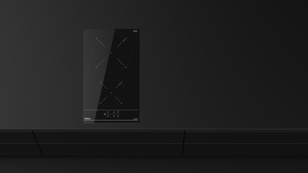 Czarna płyta indukcyjna z dwoma palnikami na czarnej powierzchni. Szafki poniżej. Widoczna marka Teka.