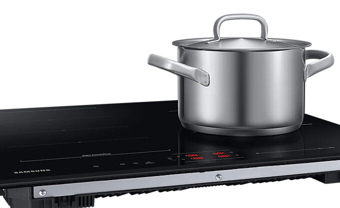 Czarna płyta indukcyjna z garnkiem na niej. Płyta ma elegancki wygląd.