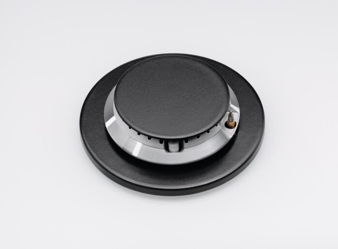 Zbliżenie czarnego palnika kuchenki z srebrną częścią centralną. Na białym tle.