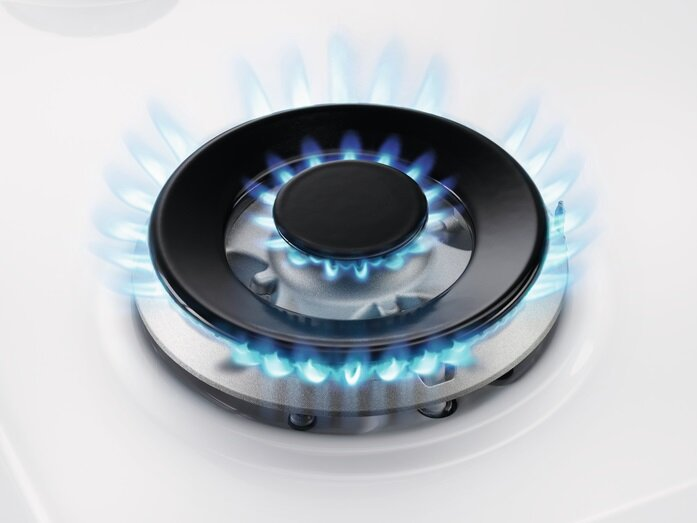 Zbliżenie palnika gazowego z niebieskimi płomieniami.