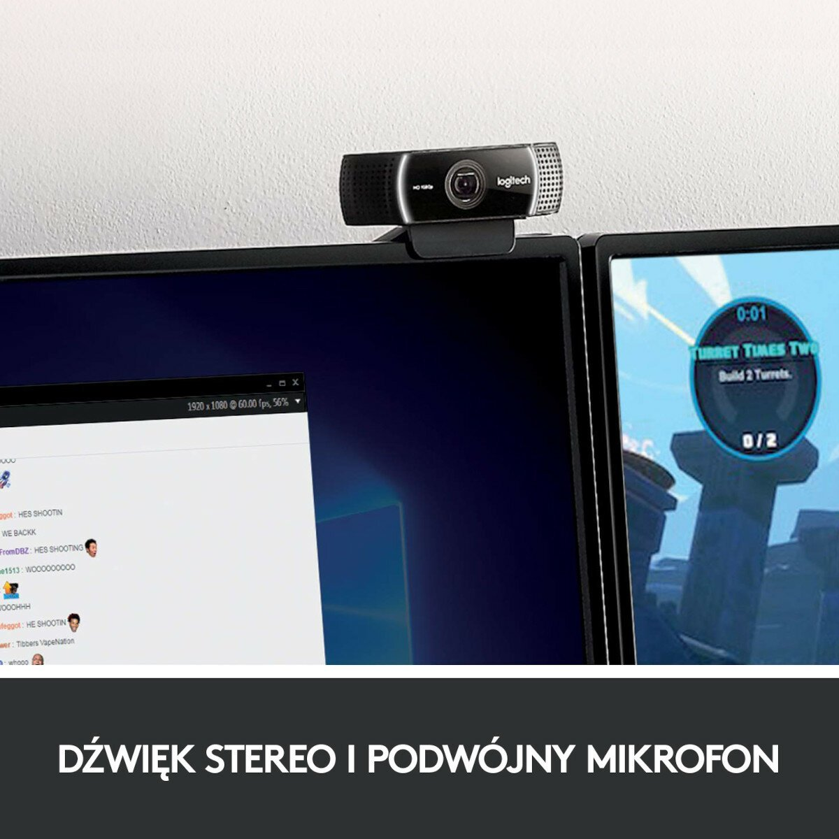 Kamera internetowa na monitorze. Dwa monitory w tle. Tekst po polsku na dole.