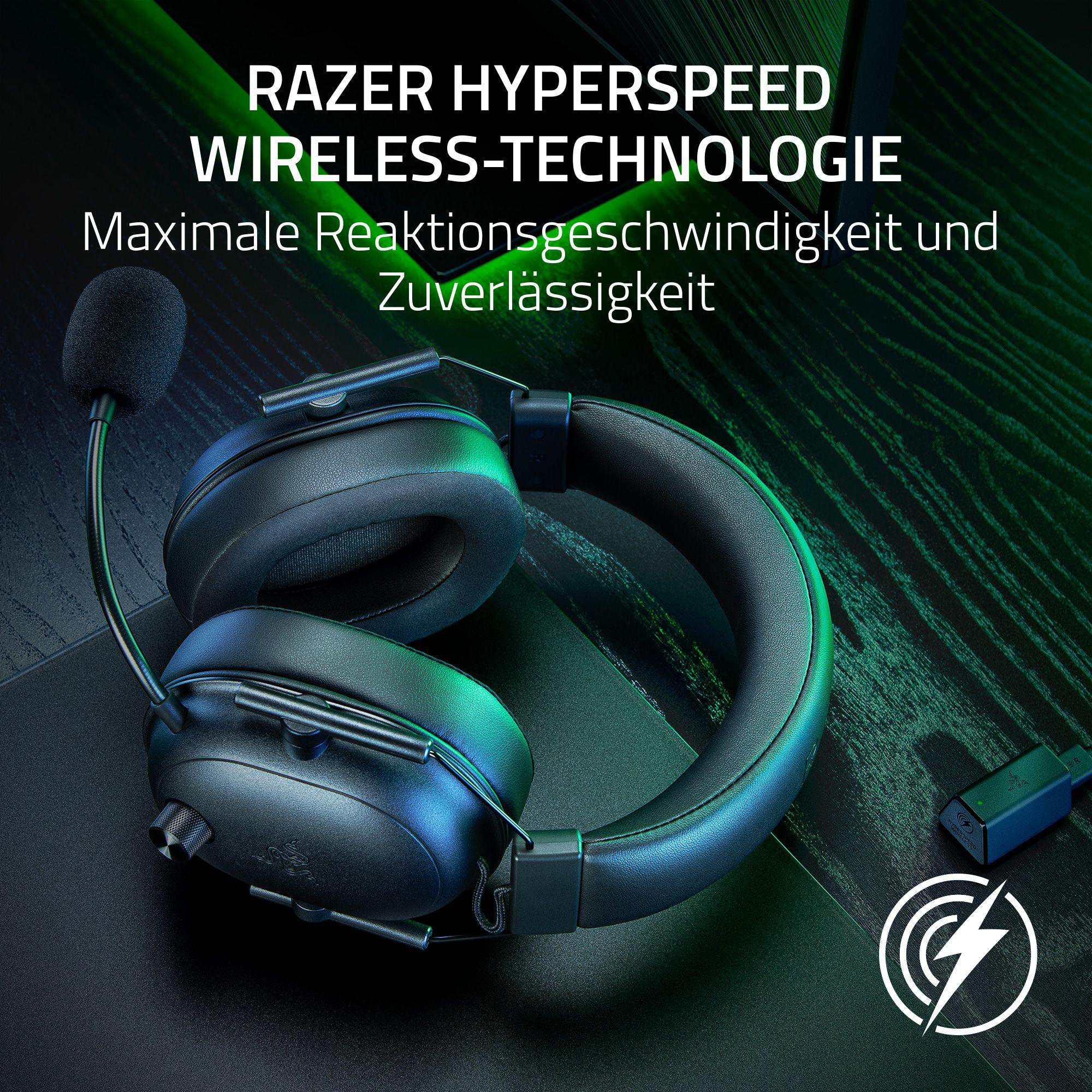 Schwarzes Razer Gaming-Headset mit Mikrofon und einem Wireless-Dongle in einem Gaming-Setup.