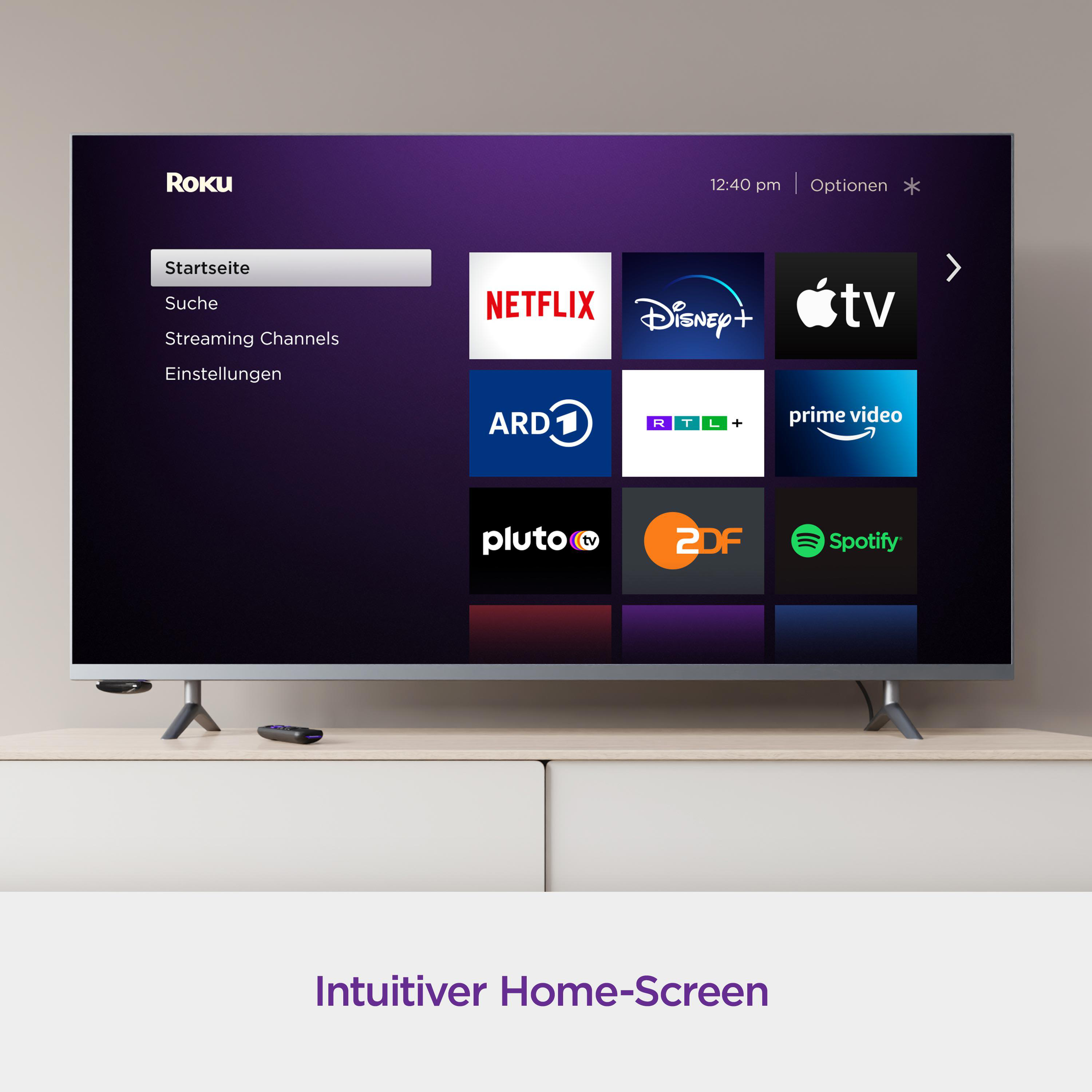 Ein Fernsehbildschirm zeigt den Roku-Startbildschirm mit Streaming-App-Symbolen. Weißer Schrank darunter.