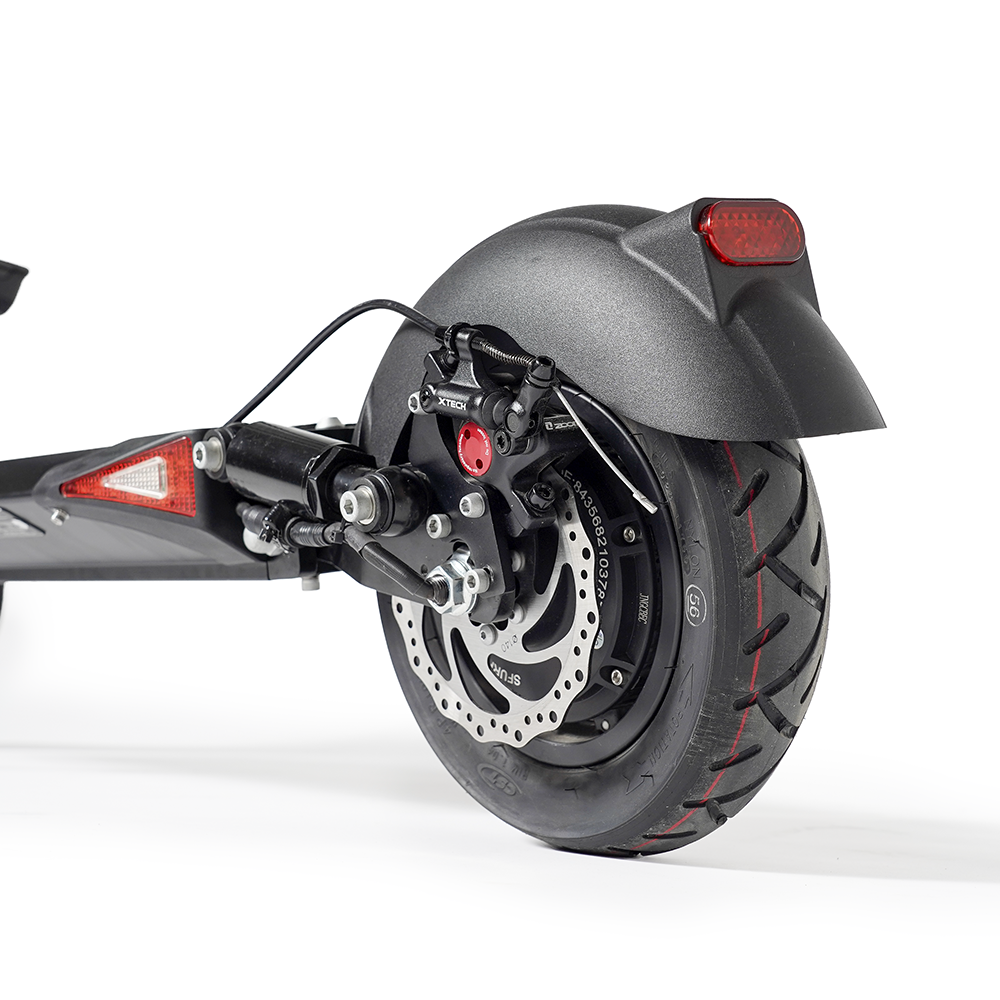 Rueda trasera de un patinete eléctrico negro con freno de disco y luz trasera roja.