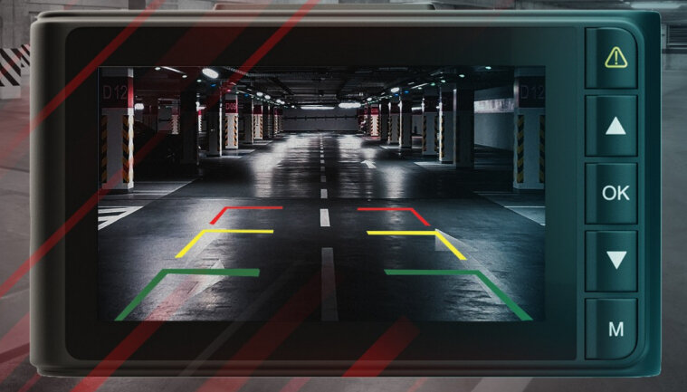 Ekran kamery cofania samochodu wyświetlający parking. Czerwone i żółte linie wskazują parkowanie.