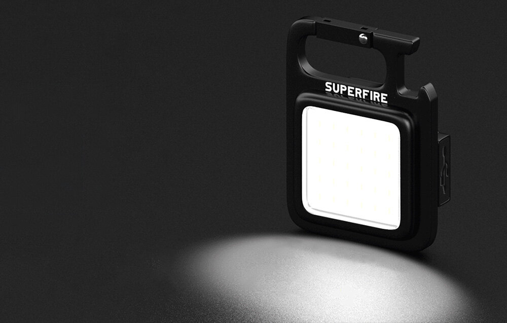 Pokazano czarną latarkę z białym światłem. Latarka jest na czarnym tle.