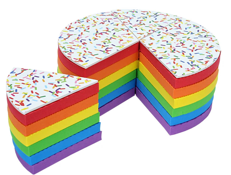 Tęczowe ciasto pokrojone na kawałki. Biała polewa z kolorową posypką na wierzchu.