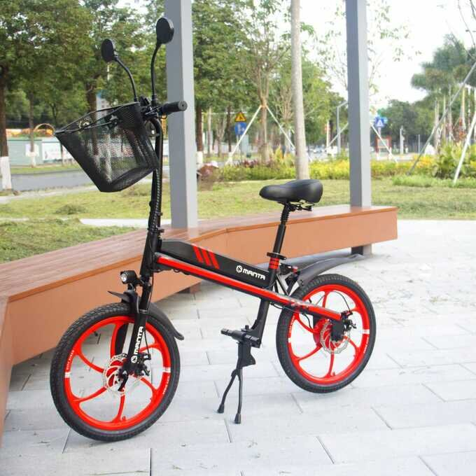 Czerwono-czarny rower na utwardzonej nawierzchni z parkiem w tle.