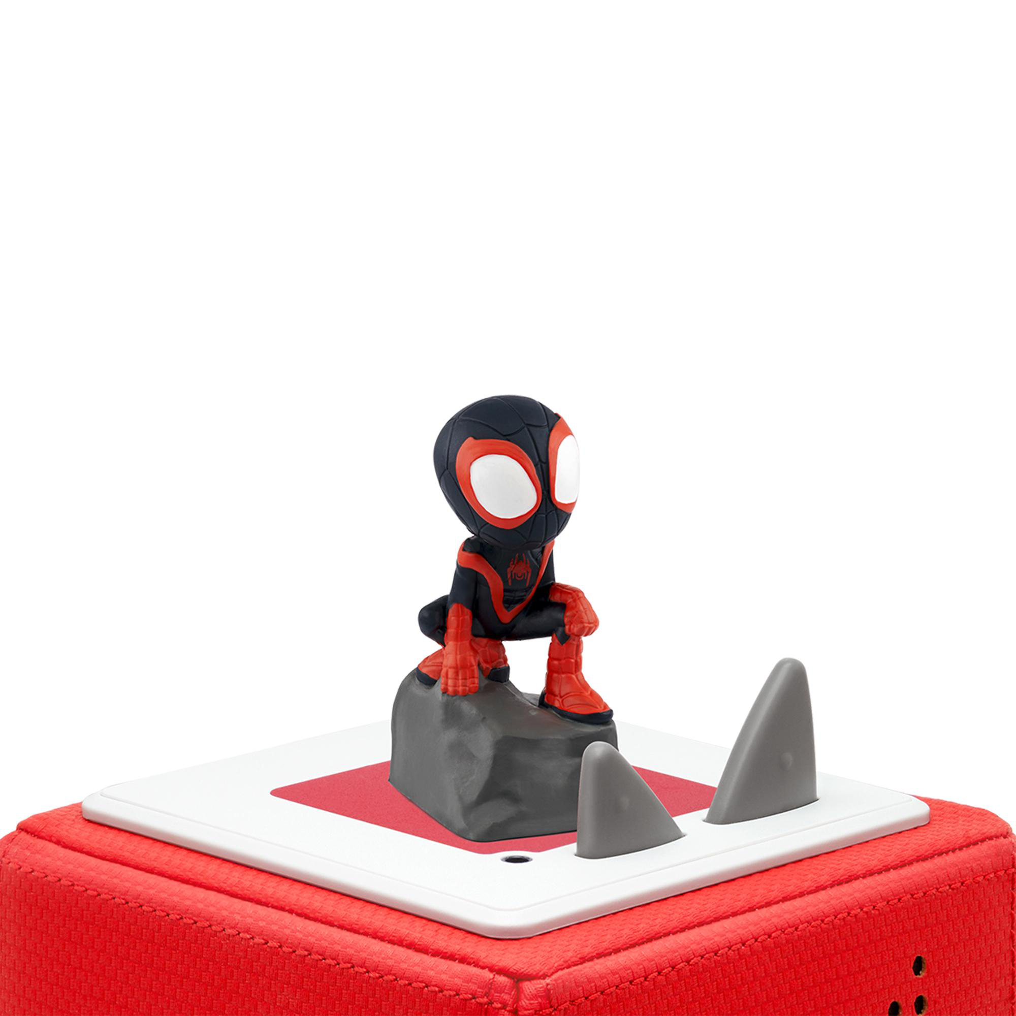 Spider-Man-Figur auf einem Felsen. Sie befindet sich auf einer rot-weißen Oberfläche mit grauen haifischartigen Flossen.