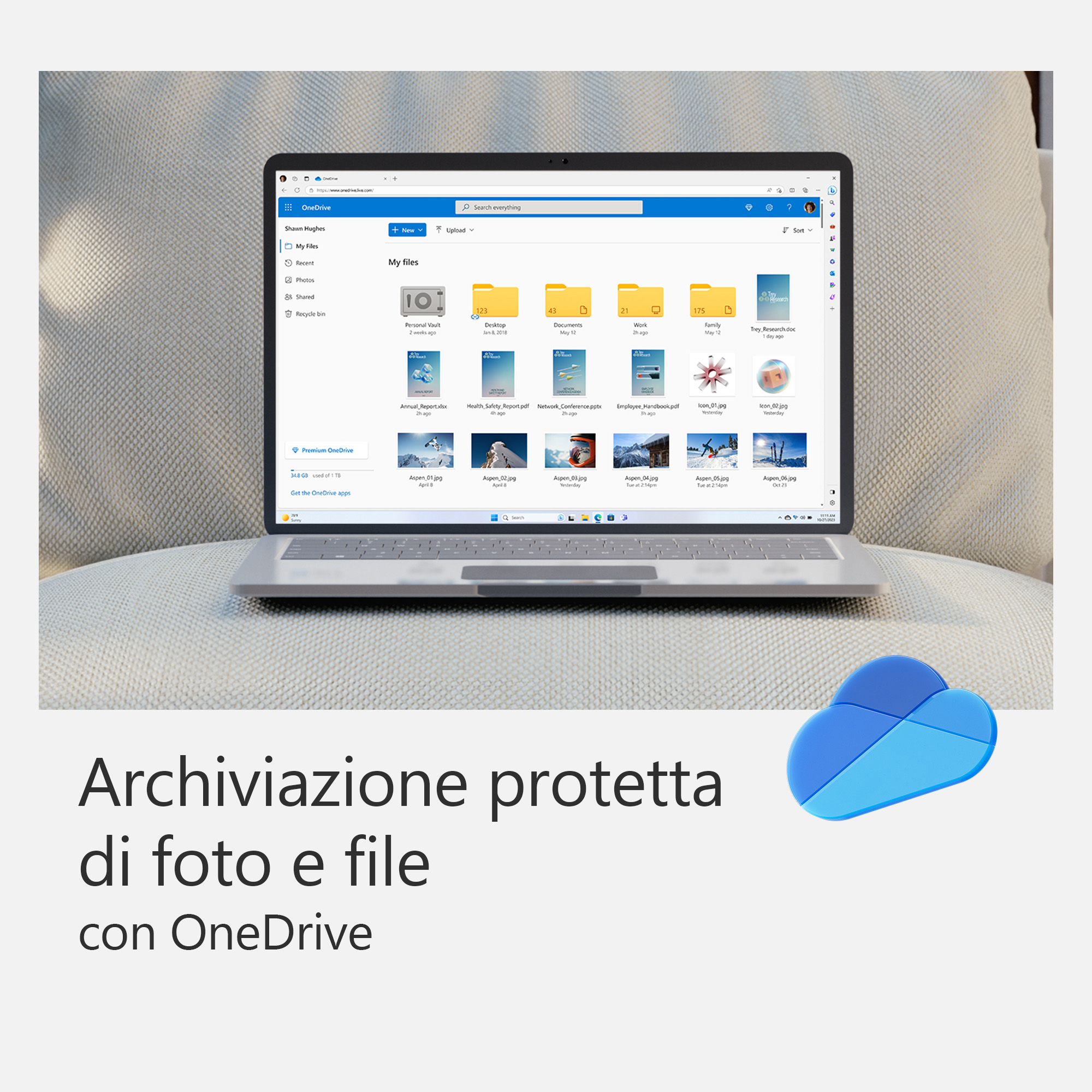 Ein Laptop auf einem Kissen, das die OneDrive-Oberfläche anzeigt. Ein blaues Wolkenlogo daneben.