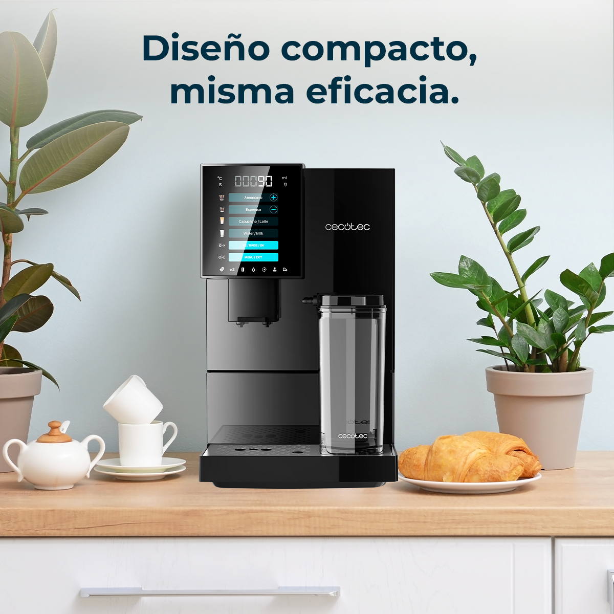 Cafetera negra con depósito de agua y cruasán sobre encimera de madera.