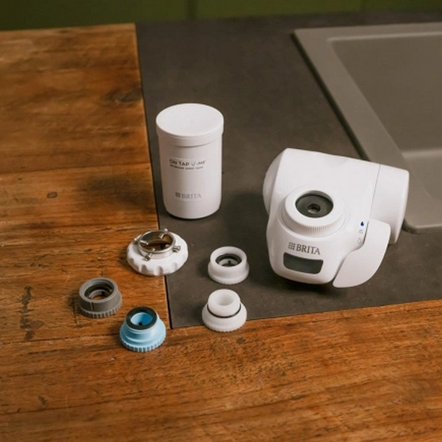 Witte Brita waterfiltercomponenten op een houten oppervlak. Inclusief filter en diverse hulpstukken.