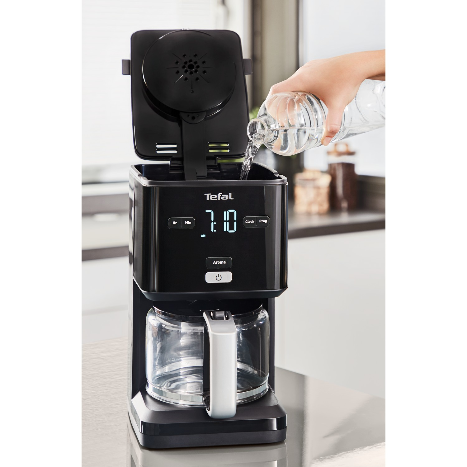 Koffiezetapparaat dat met water wordt gevuld, zwart en glas.