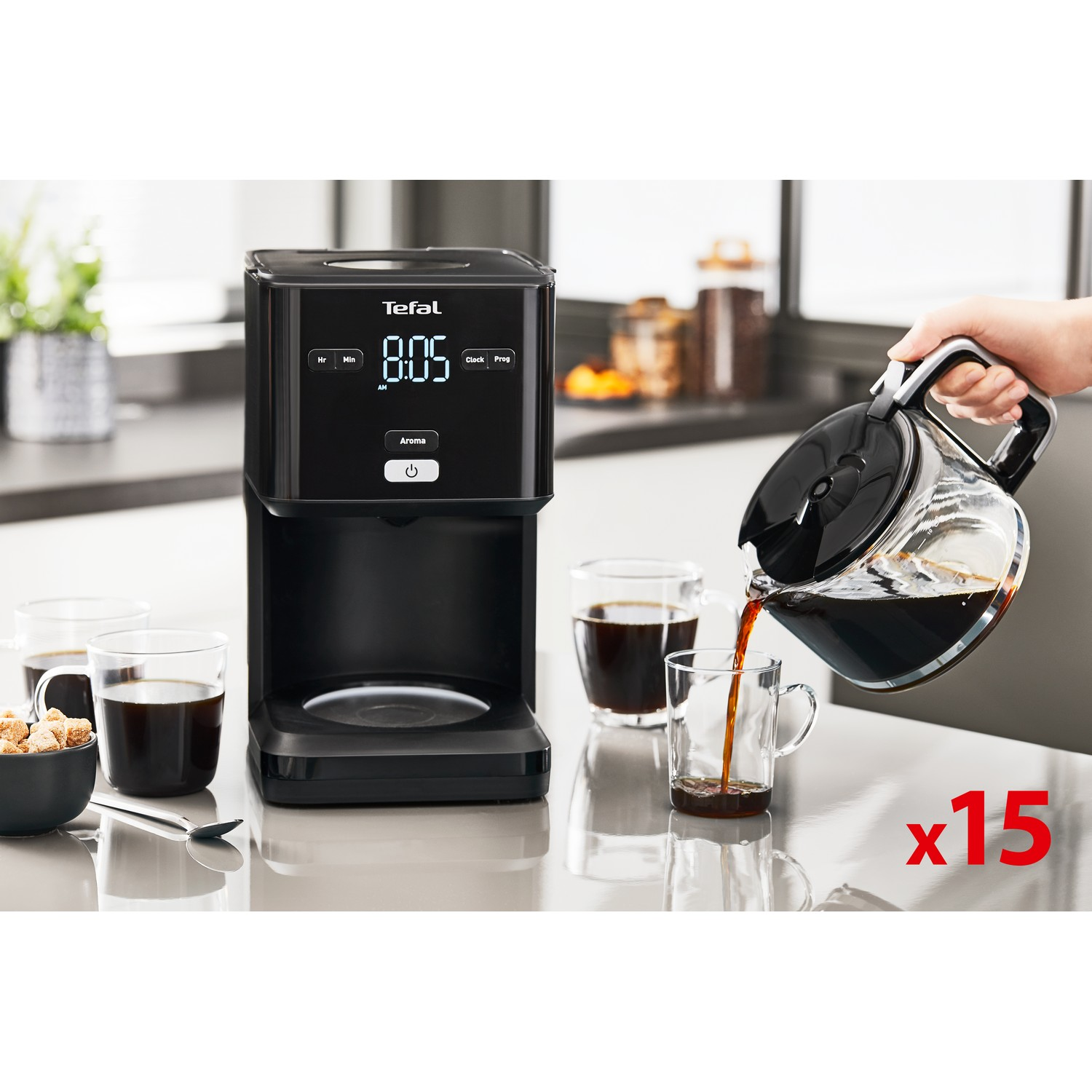 Zwarte koffiemachine met digitaal display, glazen kan en 3 kopjes.