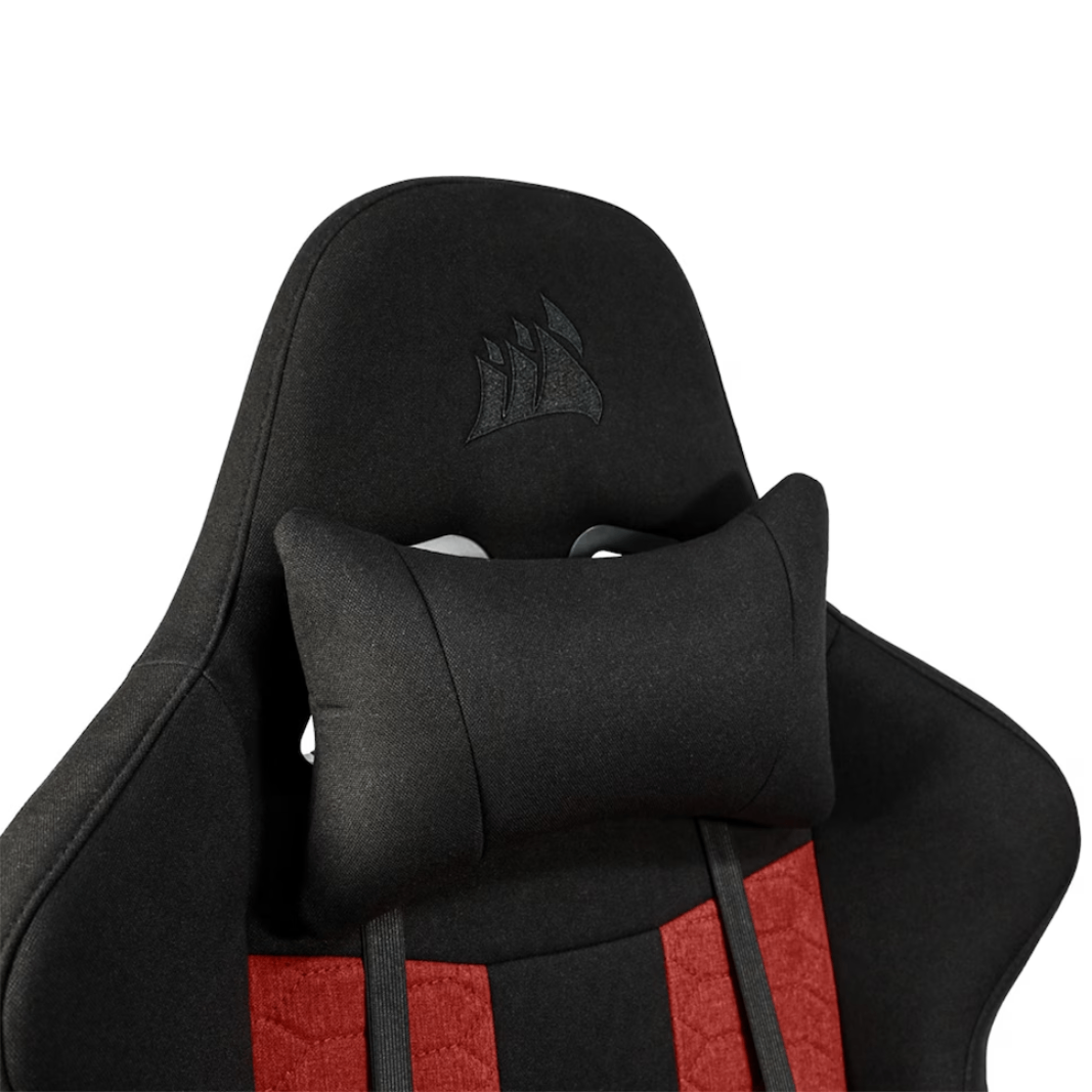 Primer plano de una silla gaming negra y roja con reposacabezas y cojín lumbar.