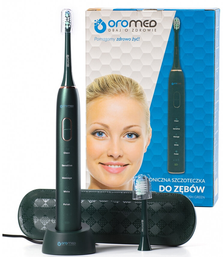 Uśmiechnięta kobieta obok elektrycznej szczoteczki do zębów z etui i podstawką ładującą.