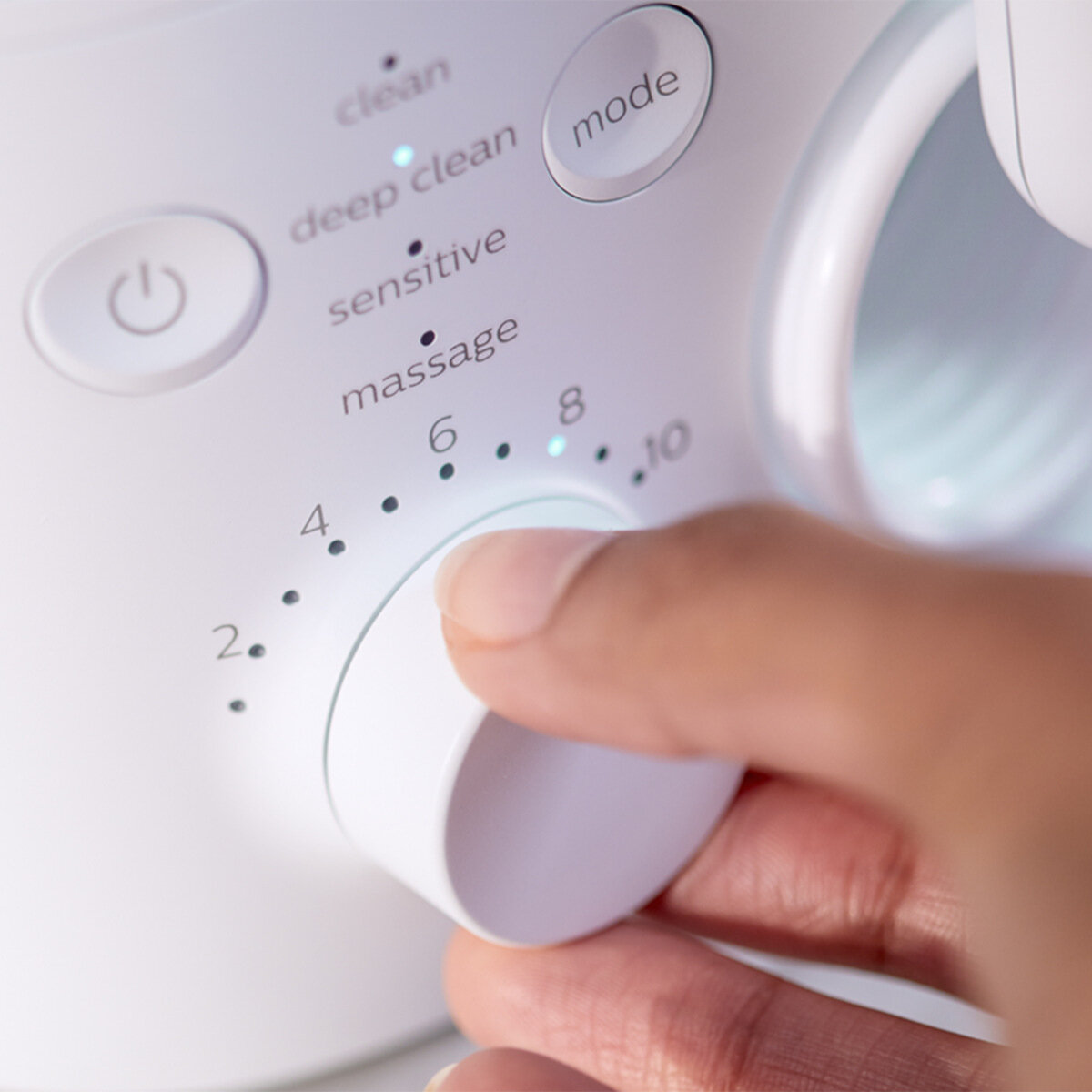 Ręka obraca białe pokrętło z ustawieniami urządzenia czyszczącego.