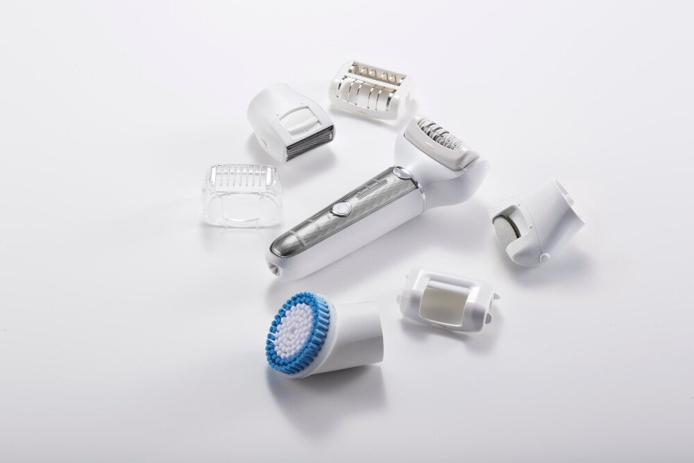 Zdemontowany depilator z częściami rozrzuconymi na białej powierzchni.