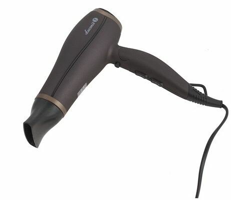 Czarno-miedziana suszarka do włosów. Na szarej betonowej powierzchni, z podłączonym kablem.