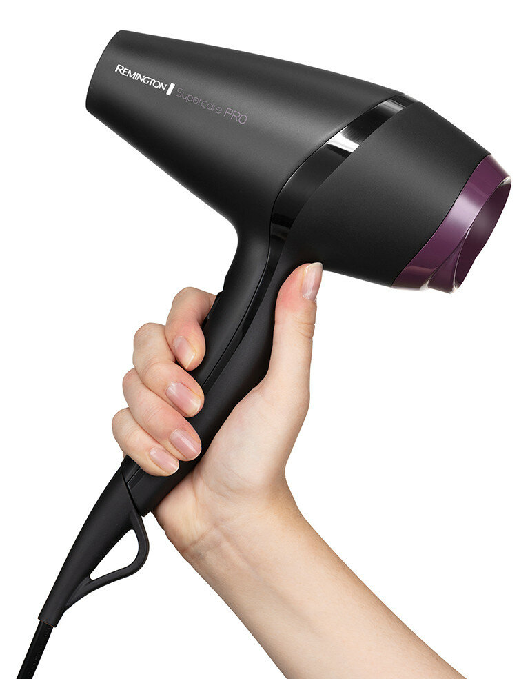 Dłoń trzyma czarną suszarkę do włosów Remington Supercare PRO na białym tle.