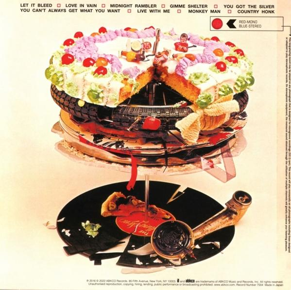 Félbevágott torta különféle feltétekkel a Rolling Stones album borítóján.