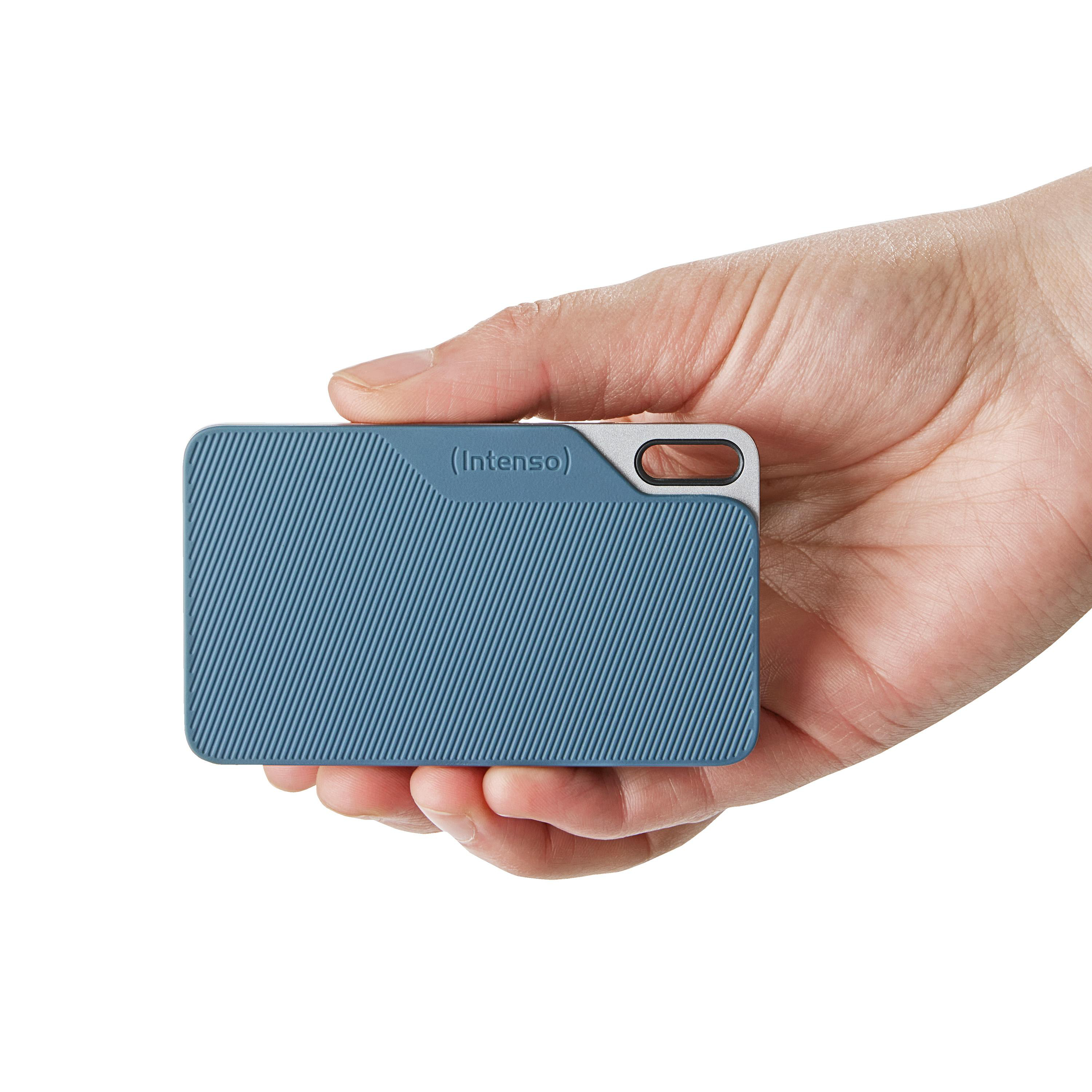 Kleine blaue und silberne externe Festplatte in einer Hand gehalten.