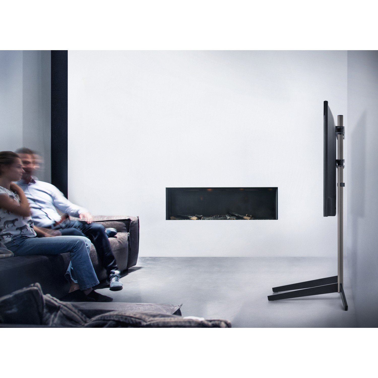 Koppel kijkt tv op een standaard in een moderne kamer.
