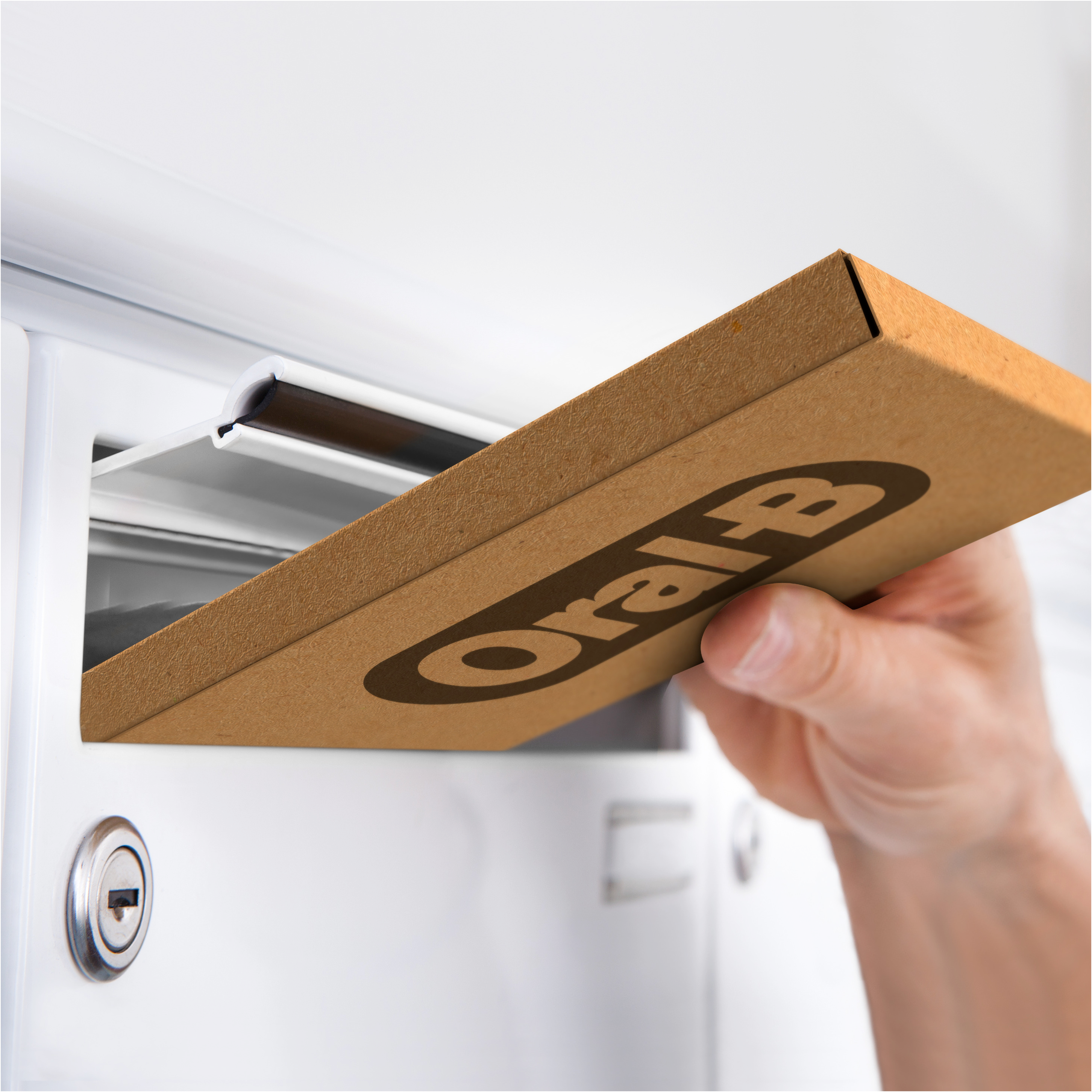 Una mano mette una scatola di spazzolini Oral-B in una cassetta postale bianca.