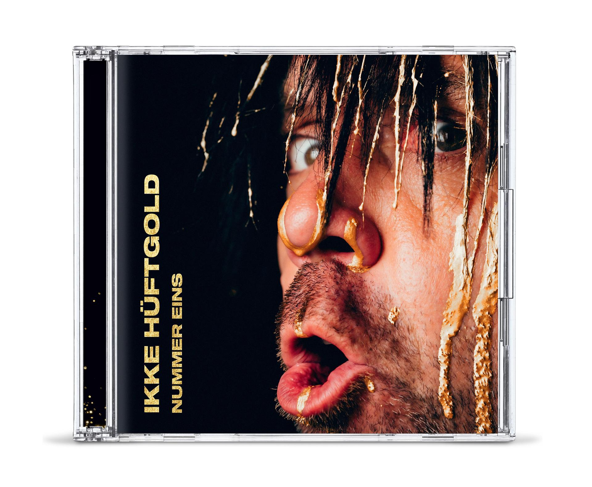 Eine CD-Hülle mit einem mit gelber Substanz bedeckten Männergesicht, mit deutschem Text.
