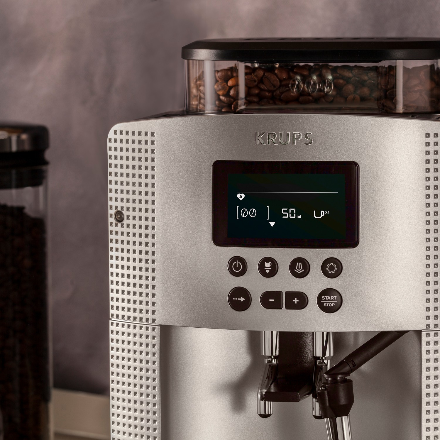 Krups coffee machine. Front view, with a display screen. Shows the grinder and beans.
