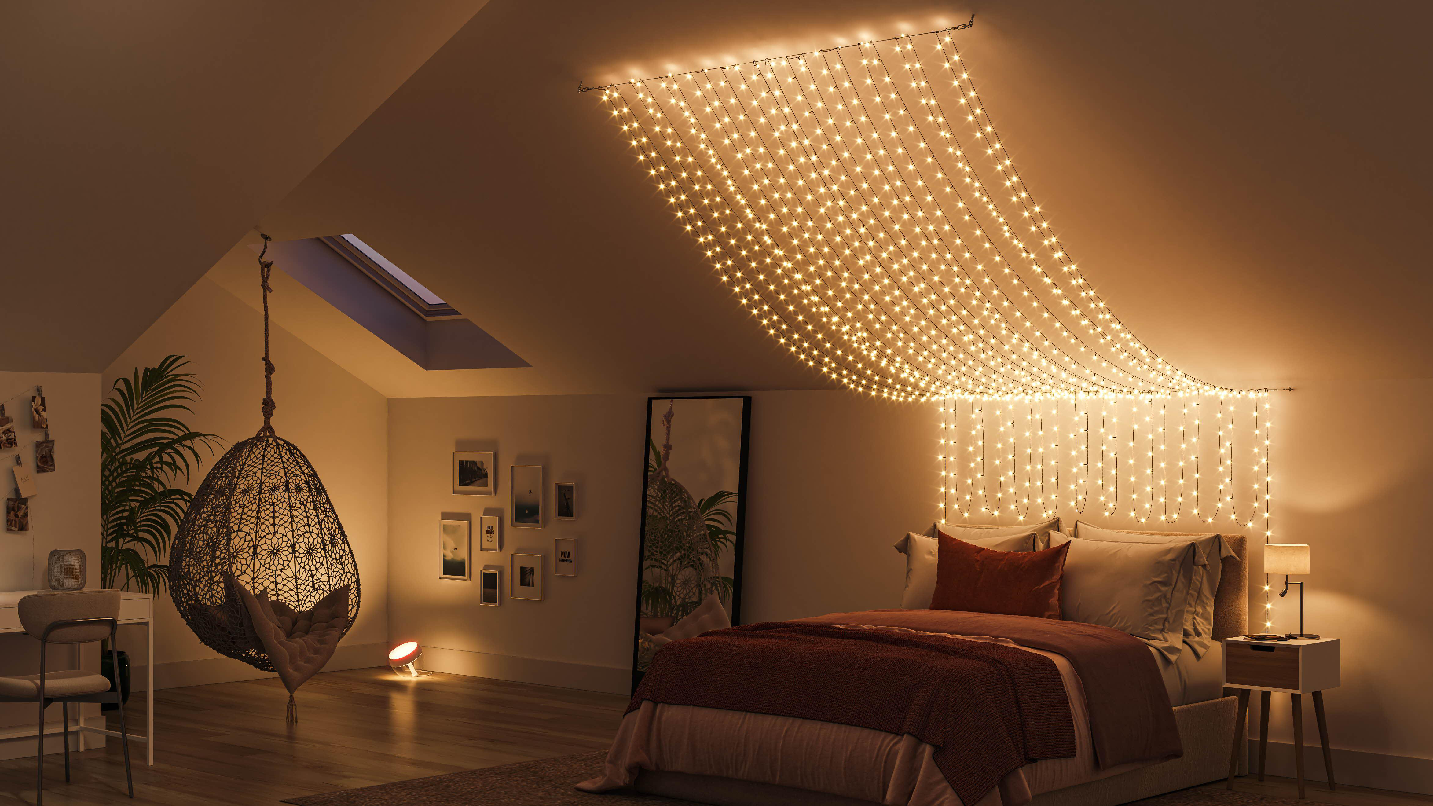 Schlafzimmer mit Lichterketten, einem Bett, einem Hängestuhl und einem Fenster.