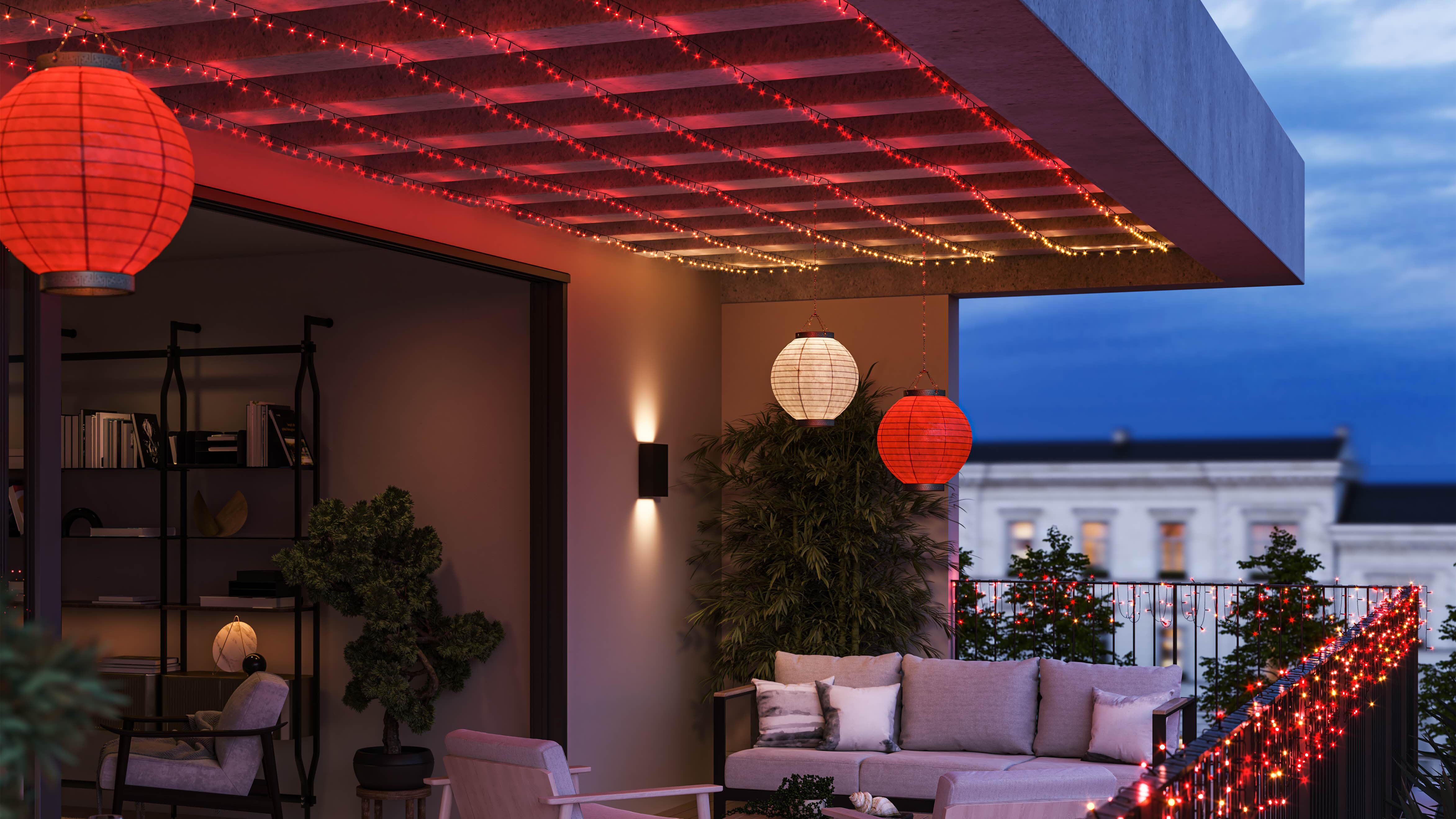 Szene im Freien mit Lichterketten, Laternen und Pflanzen auf einem Balkon. Nachtzeit.