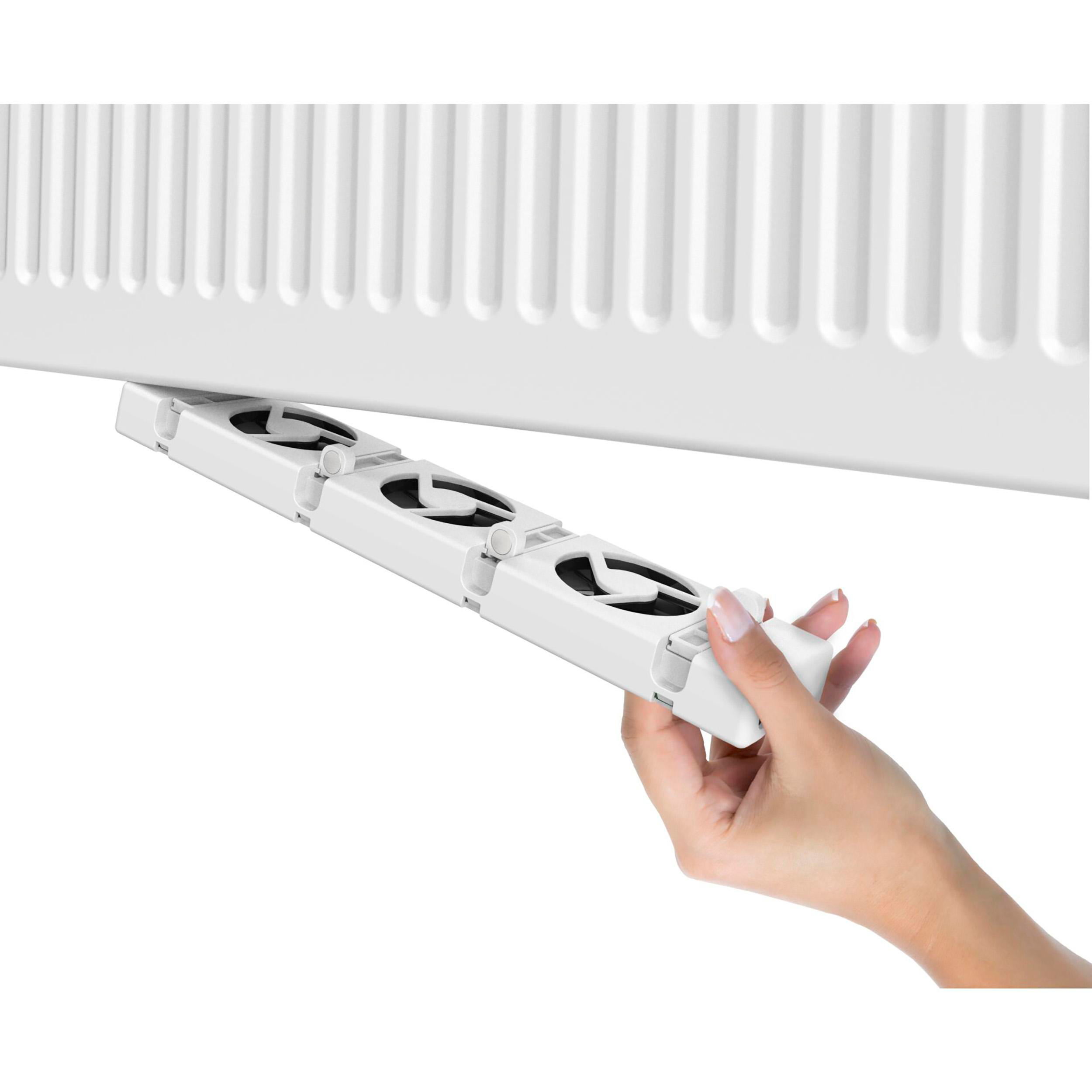 Ein weißer Heizkörper mit einer daran befestigten weißen Lüftereinheit wird von einer Hand gehalten.