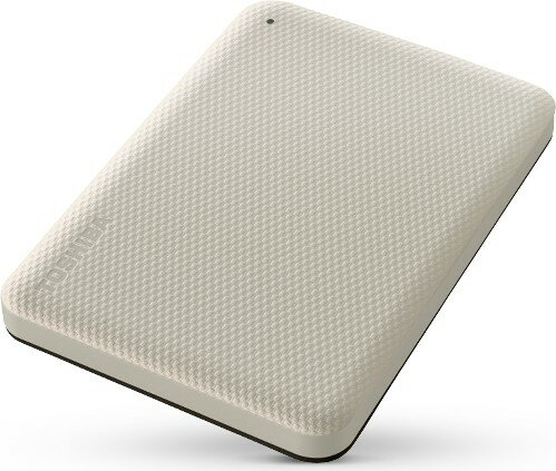 Kremowy dysk twardy zewnętrzny Toshiba. Ma teksturowaną powierzchnię z logo Toshiba i małą czarną kropką.