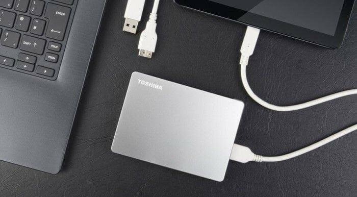 Laptop podłączony do przenośnego dysku twardego Toshiba.