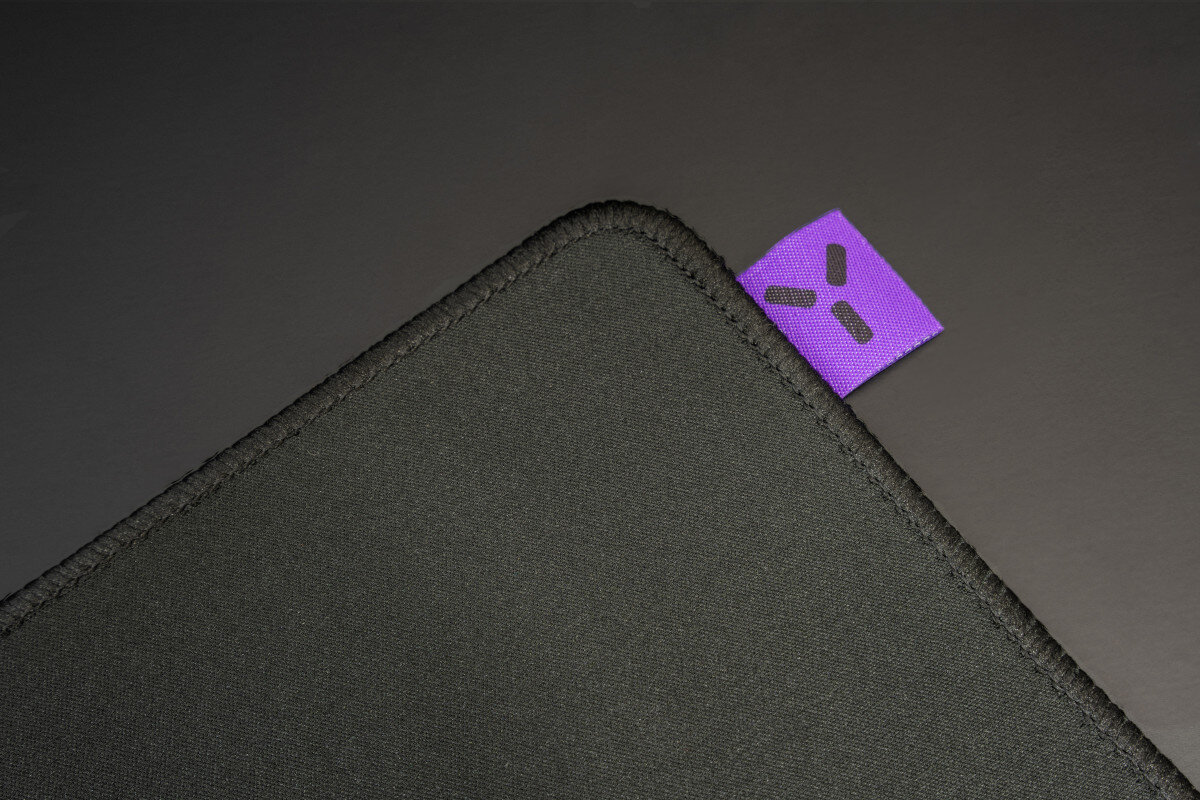 Czarna podkładka pod mysz dla graczy z fioletową etykietą z logo w rogu.