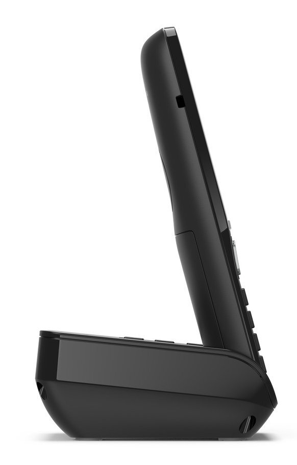 Czarny telefon bezprzewodowy na ładowarce. Widok z boku, białe tło.