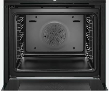 Wnętrze piekarnika. W środku jest ciemno, z wentylatorem na tylnej ścianie.