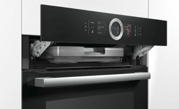 Czarny piekarnik z wysuniętym panelem sterowania. Srebrne drzwi i wnętrze piekarnika.