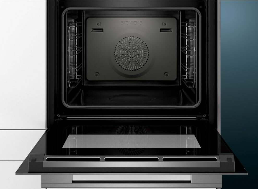 Otwarty wnętrze piekarnika. Wnętrze ze stali nierdzewnej z wentylatorem z tyłu, szklane drzwi.