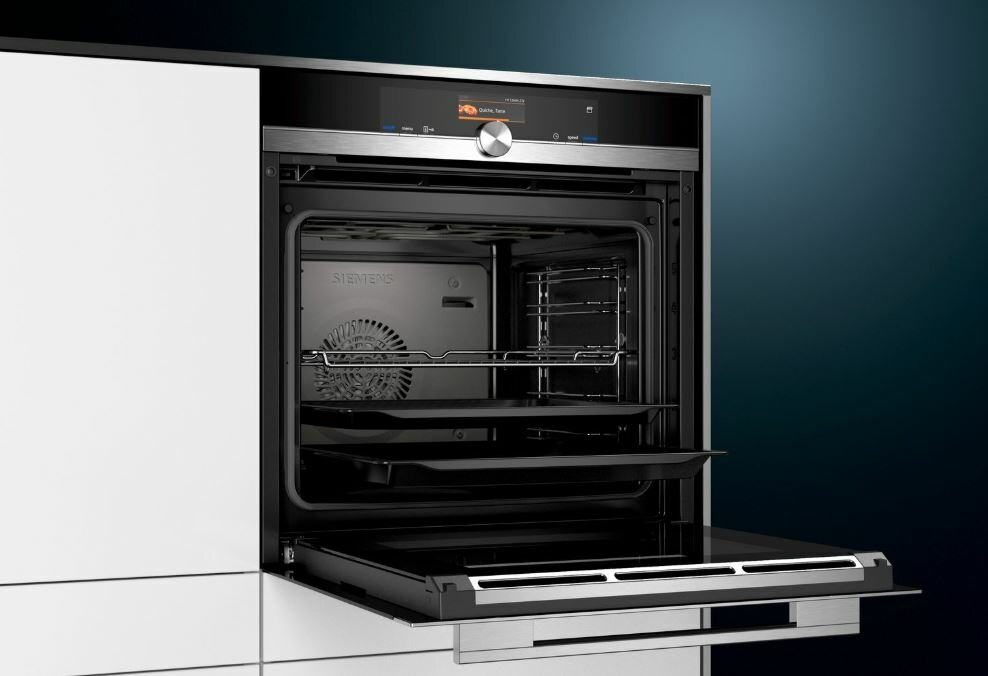 Otwarty piekarnik z wieloma rusztami, pokazujący wnętrze z metalowym wentylatorem.